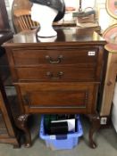 A 20th Century cabinet on cabriole legs featuring 2 drawers over 1 cupboard