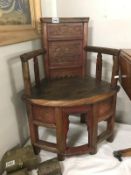 A wooden corner chair featuring floral carvings