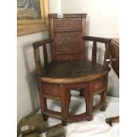 A wooden corner chair featuring floral carvings