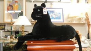 A black jaguar stuffed toy with battery compartment