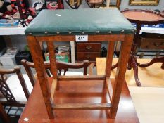 A tall oak stool with green top