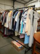 A rail and box of vintage and modern clothing including shirts, coats, dresses, jackets etc.