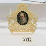 A hand painted 19th century miniature portrait on porcelain (chip to edge) in a decorative 19th