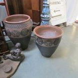 A set of 4 large earthenware garden pots.
