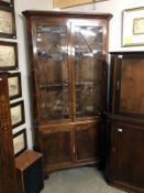 A glazed top corner display cabinet