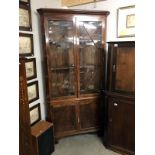 A glazed top corner display cabinet