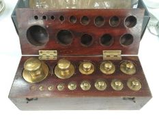 A cased set of Baird and Tatlock London brass weights (1 missing)