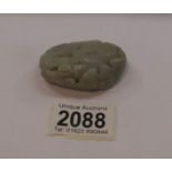 An item of jade featuring depictions of man, bird and fish.