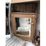 A pine wall cabinet with mirrored door