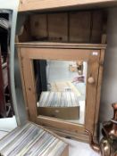 A pine wall cabinet with mirrored door