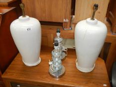 A pair of retro chrome and acrylic table lamps and a pair of pottery table lamps