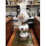 A floral overlaid white glass oil lamp style electric lamp