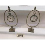2 silver pocket watches on stands, both a/f.