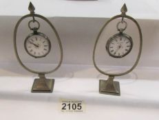 2 silver pocket watches on stands, both a/f.