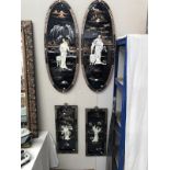 A pair of black lacquered oval plaques and a pair of black lacquered rectangular plaques depicting