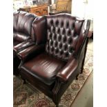 An oxblood wing back armchair