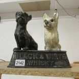 An antique aluminium Buchanan's Black and White Whisky advertising dogs.