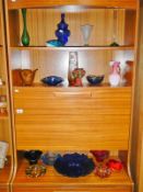3 shelves of coloured art glass including bowls,