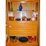 3 shelves of coloured art glass including bowls,