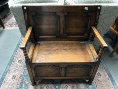 An oak monk's bench with under seat compartment