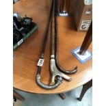 A walking stick with ball and claw handle and silver collar,