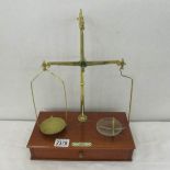 A set of brass beam scales with wooden drawer base. de Grave, Short & Co.