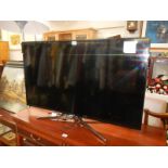 A Samsung flat screen TV with remote