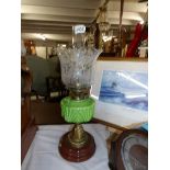 A Victorian oil lamp with moulded green glass font and original shade (shade a/f).