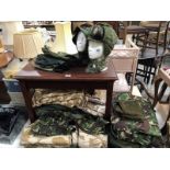 A large quantity of UK combat clothing including boiler suits, T-Shirts, jackets and hats etc.