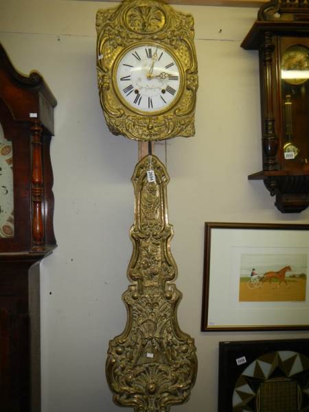 A French brass wall clock with pendulum.