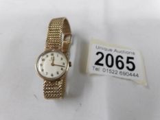 An Omega ladies 9ct gold wrist watch and bracelet, in working order.
