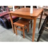 A stained pine kitchen table with 2 stools