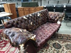 A 19th Century deep buttoned leather sofa (distressed) not visibly marked but possibly Howard &