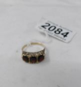 A 9ct gold ring set 3 red stones, size R.