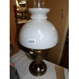 A brass oil lamp complete with shade and chimney.