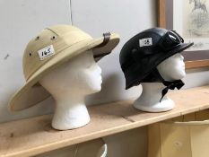 A pith helmet and helmet with goggles