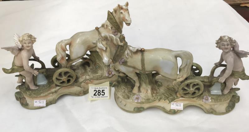 A pair of cherub figurines ploughing with horses A/F