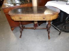 A Victorian table on carved stretcher base and with leather inset top.
