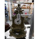 A small spelter mantel clock surmounted cherub.