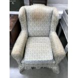An Edwardian wing arm chair with turned legs