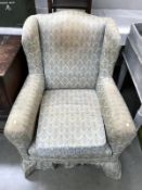 An Edwardian wing arm chair with turned legs