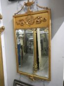 A gilt framed 'Romanesque' bevel edged mirror, minor damage, approximately 104 x 54 cm.