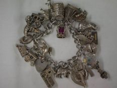 A silver charm bracelet with silver and white metal charms (approximately 94 grams).