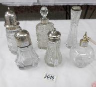 5 glass items with silver tops including sugar sifters and a glass and silver plate perfume bottle.