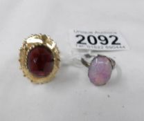 An unmarked yellow metal ring set red stone, size O and a silver ring, size P.