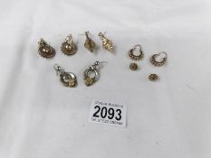 4 pairs of unmarked yellow metal earrings and a pair of white metal earrings.