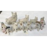 A quantity of bisque porcelain dogs including a pair with boy and girl figures