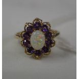 A floral head 9ct gold dress ring with petals of purple stones and central opal. size O.