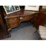 A walnut veneer desk with leather inset top.