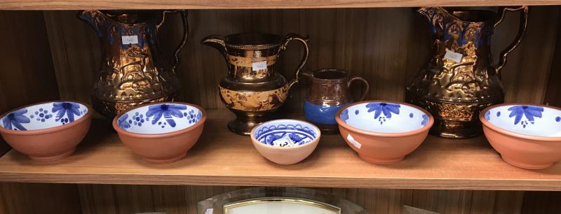 A quantity of lustre ware jugs and blue and white terracotta dishes